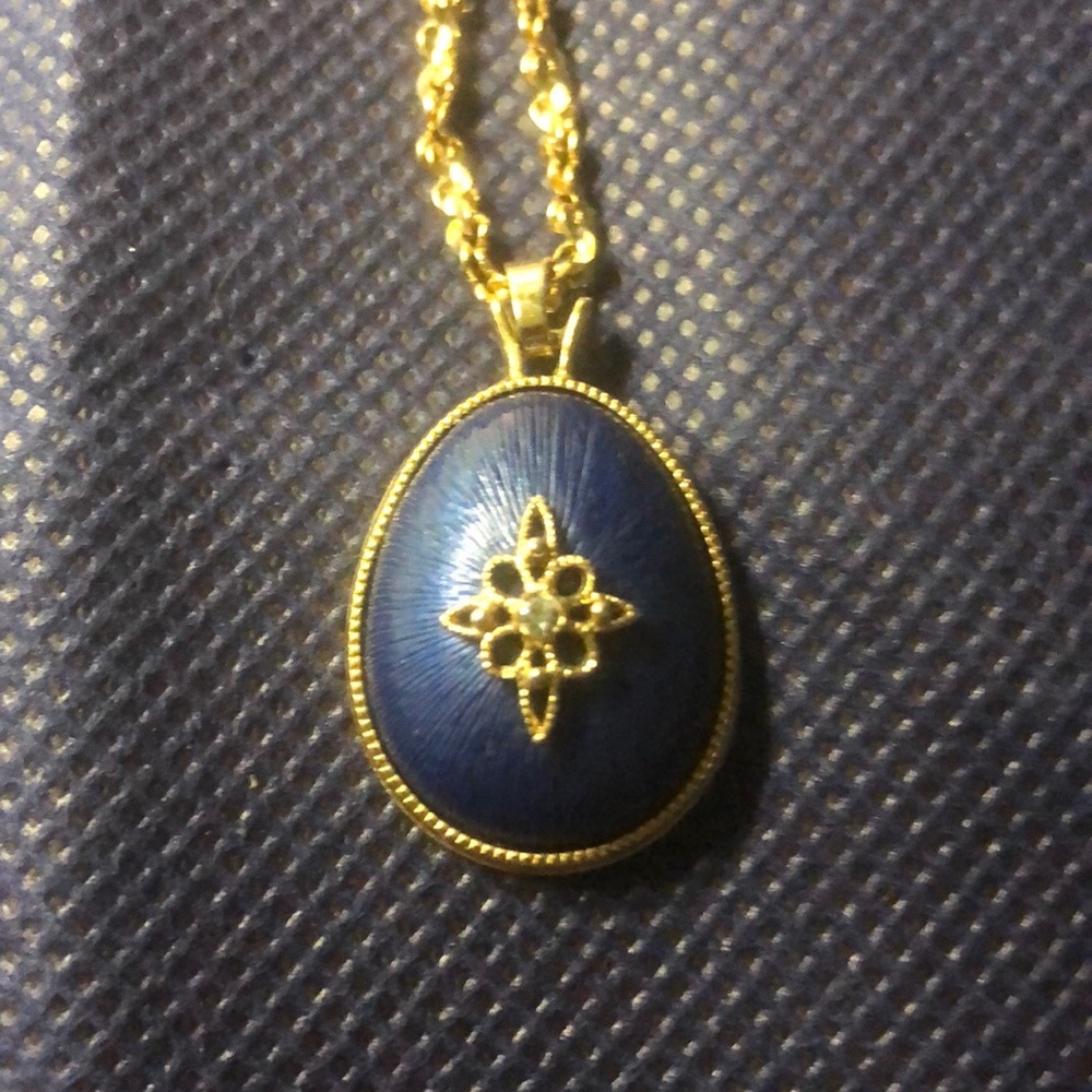Beautiful gold tone necklace with a blue pendant